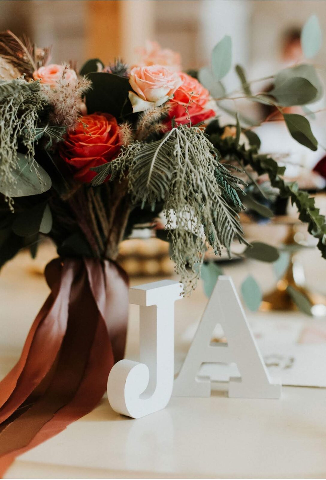 Bridal bouquet with burgundy and cream-colored flowers in rustic-boho style