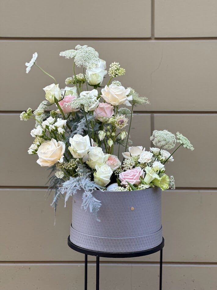 Ziedu kaste ar baltām un rozā rozēm elegantā noformējumā