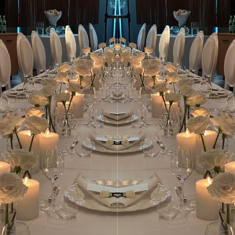 Elegantly decorated table with white roses and lots of candles